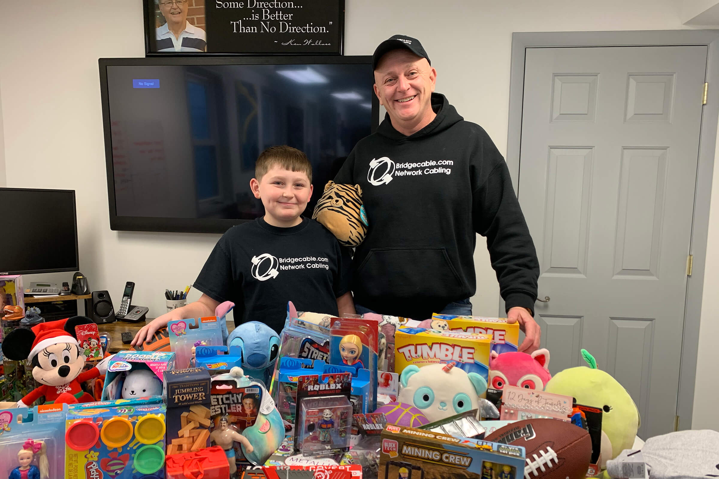 Our Pay It Forward Program 37 posing in front of toy donations