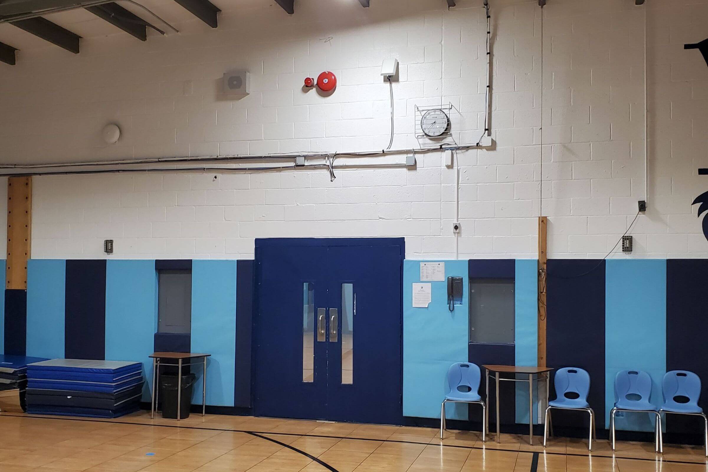 Education 302 A gymnasium with mats and chairs.