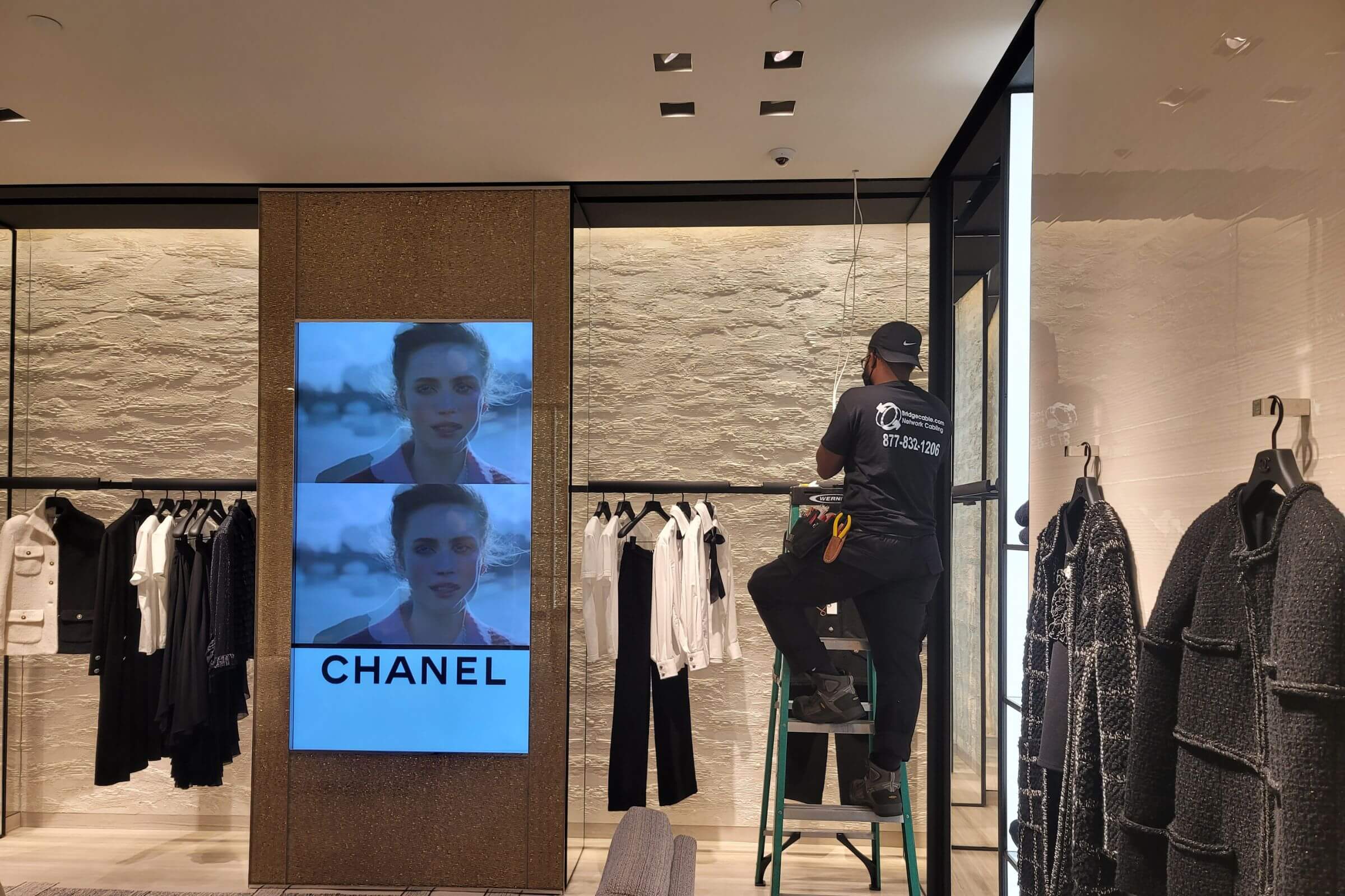 Retail 265 Technician on a ladder in Chanel store