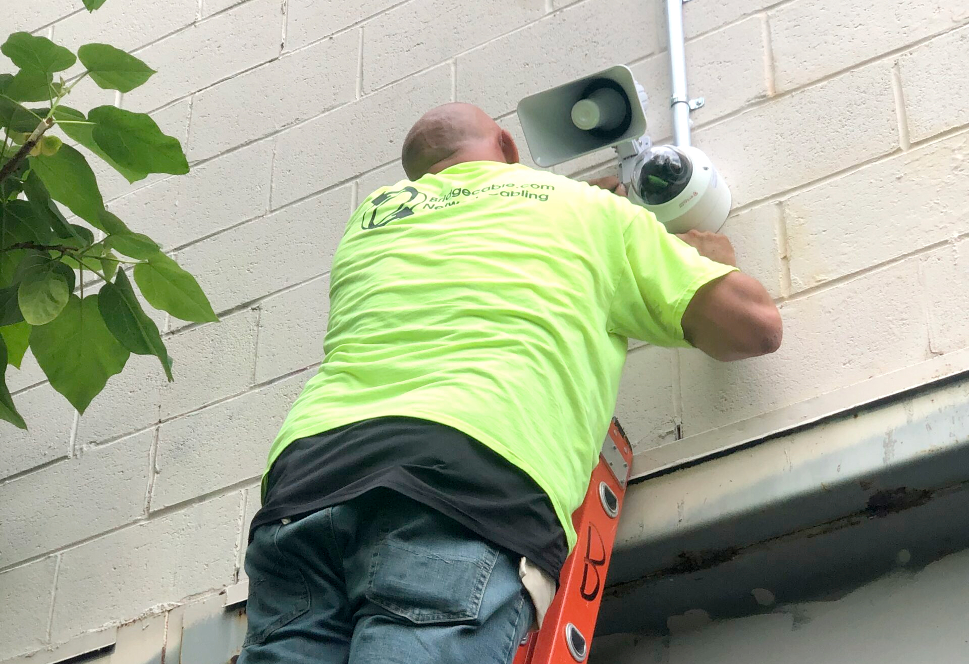 A technician installing a security camera outside