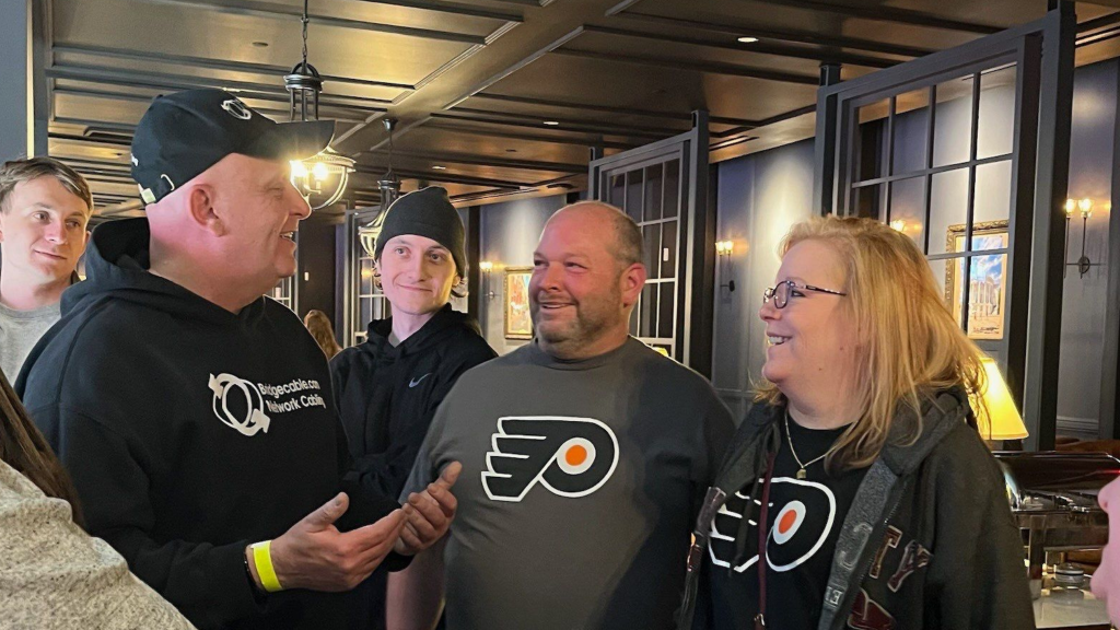 Home 149 Network cabling team talking to two clients in flyers shirts