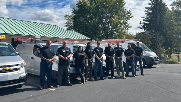 Network Cabling team outside in front of the company vans all with black t shirts on
