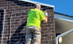 cabling tech installing security systems on a ladder