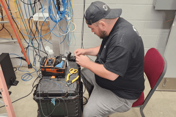 Technician handling fiber and CAT6 cabling maintenance in an Evesham, NJ data center.