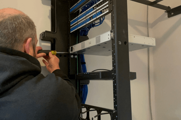 Technician Performing Network Cabling Maintenance in Wilmington, DE Data Center
