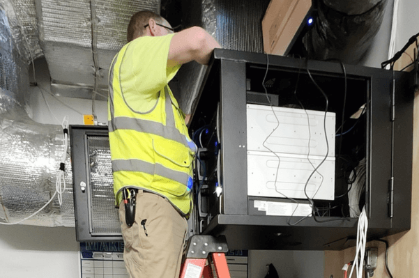 Technician working on network rack infrastructure in a King of Prussia, PA data center