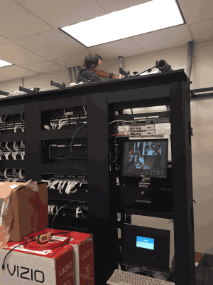 How Distribution Centers Depend on Reliable Structured Cabling Services for Peak Performance 2 A technician works atop a network rack, installing and organizing cabling and equipment in an active server room setup