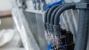How Division 26, 27 & 28 Electrical Codes Support Structured Cabling and Security Infrastructure 1 Close-up of commercial electrical conduit, flexible wiring, and control system connections installed inside an industrial electrical infrastructure environment.