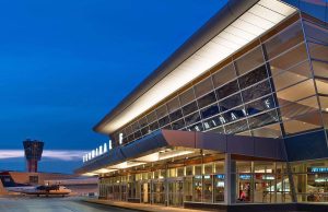 Philadelphia International Airport terminal exterior illuminated at night with airport control tower in the background