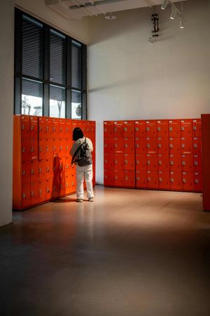 Smart Lockers and Access Control System Integration with Bridge Cable 3 Person using smart lockers with integrated access control system in a modern commercial facility with secure workplace storage and advanced security technology.