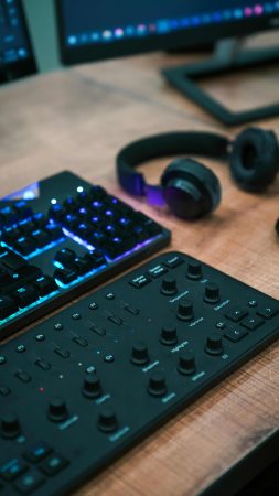 How Structured Cabling Supports Podcasters and Live Streamers 2 Audio control panel, RGB keyboard, headphones, and computer monitors on a professional streaming desk setup.