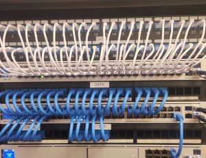 How Division 26, 27 & 28 Electrical Codes Support Structured Cabling and Security Infrastructure 5 Structured cabling patch panels with organized ethernet cables installed inside a commercial network rack for data communications infrastructure.