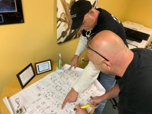 TIA Standards and Their Impact on Network Cabling 4 Two Bridge Cable technicians examining construction blueprints and network infrastructure plans during a project coordination meeting.