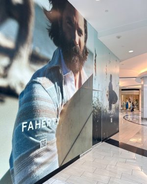 How ShopperTrak Solutions Improve Retail Performance 4 Large FAHERTY wall graphic installed on a shopping mall storefront featuring lifestyle imagery and promotional branding.