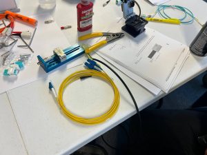 Mass Production Makes Single Mode Fiber More Affordable 1 Fiber optic termination workstation with single mode fiber cable, connectors, cleaver, and installation tools used for network infrastructure projects.