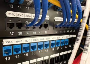 TIA Standards and Their Impact on Network Cabling 3 Network patch panels with labeled CAT6 ports and Ethernet patch cables organized according to TIA-606 telecommunications administration standards.