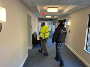 NAICS Code 238210 and Bridge Cable: Delivering Reliable Connectivity 5 Two Bridge Cable technicians performing a wireless site survey and project assessment inside a commercial facility hallway.