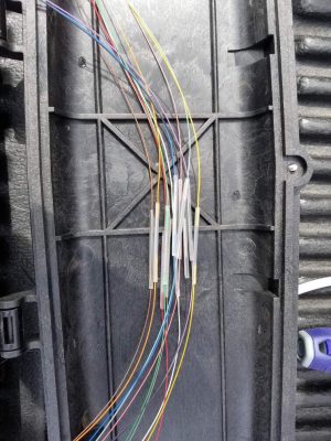 Fiber Optic Contractor: Why They Are Becoming the Standard in Pennsylvania 1 Color-coded fiber optic strands with clear splice protection sleeves arranged inside a black plastic fiber splice tray or enclosure by a fiber cabling contractor