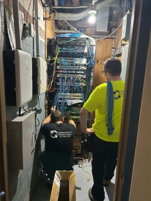 Network Downtime Cost for Pennsylvania Businesses 1 Two technicians repairing a network rack in a server closet, reducing network downtime cost for Pennsylvania businesses.