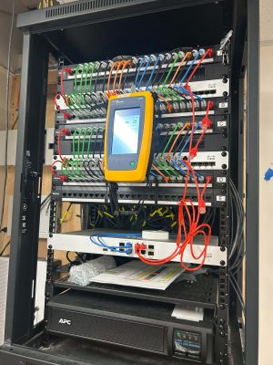 Network Downtime Cost for Pennsylvania Businesses 4 Organized network rack with Fluke cable tester, Cisco switches, and UPS, illustrating network downtime cost prevention for Pennsylvania businesses.