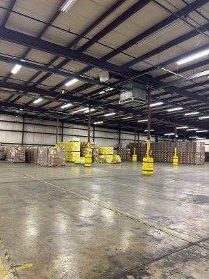 Why Your Inventory Heatmap Must Match Peak Stock 2 Warehouse with pallets and boxes stacked along the walls and an open center floor, showing partial inventory levels.