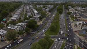 What Role Does Low Voltage Play in Speed Camera Systems? 2 Aerial view of Roosevelt Boulevard in Philadelphia showing multiple traffic lanes divided by a grass median, rowhomes lining both sides, and vehicles moving through a signalized intersection.